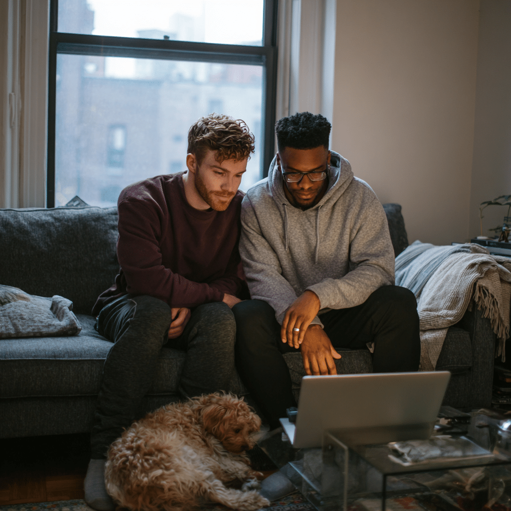 Couple in an online couples therapy NYC session experiencing a moment of recognition with their therapist on screen.